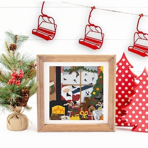 Könnte beinhalten: Eine gerahmte Illustration von Weihnachtsmann in einem Kamin mit einem Weihnachtsbaum und Geschenken. Die Illustration ist umgeben von roten und weißen Tupfen-Weihnachtsbäumen und roten Skilift-Dekorationen.