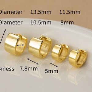 May include: Four gold-colored hoop earrings of varying sizes are displayed. The outer diameters are 13.5mm and 11.5mm. The inner diameters are 10.5mm and 8mm. The thickness measurements are 7.8mm and 5mm. The earrings are on a white surface.