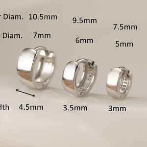 Puede incluir: Se muestran tres pendientes de aro plateados de diferentes tamaños. El más grande tiene un diámetro exterior de 10,5 mm, un diámetro interior de 7 mm y un ancho de 4,5 mm. El más pequeño tiene un diámetro exterior de 7,5 mm, un diámetro interior de 5 mm y un ancho de 3 mm.