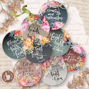 May include: A collection of round tags with floral designs and inspirational quotes. Each tag features a different quote in elegant script, surrounded by watercolor flowers in shades of pink, orange, and green. Some tags have a gradient background.