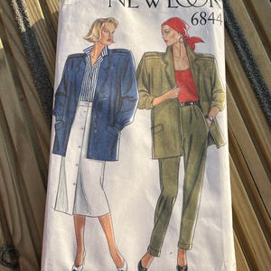 Op de afbeelding: Een vintage naaipatroon van New Look, patroonnummer 6844, met twee vrouwen die jassen dragen. De vrouw links draagt een blauwe jas met een witte rok, en de vrouw rechts draagt een groene jas met een groene broek. De tekst "Trousers not included" staat onderaan het patroon gedrukt.