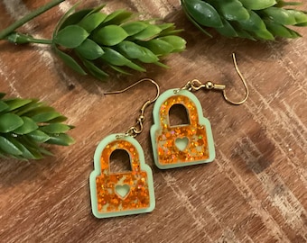 Orange glitter and green showgirl lock earrings. Trendy, pop of sparkle for any wardrobe.