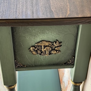 Hand-painted and sculpted console table with dimensional golden mushrooms on rich dark green background, dramatic artisan woodland motif, collectible functional art furniture.