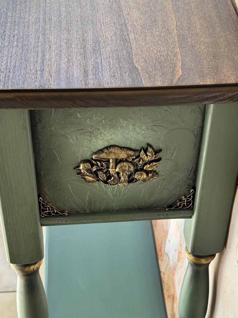 Hand-painted and sculpted console table with dimensional golden mushrooms on rich dark green background, dramatic artisan woodland motif, collectible functional art furniture.