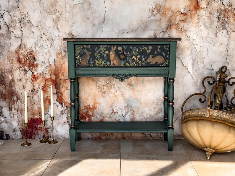 Unique artisan console table in deep green with hand-painted floral and animal artwork on the front panel, ornate carved scroll details, handcrafted decorative furniture for entryway, hallway, or living room.