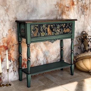 Hand-painted green console table with ornate carved details and decorative floral and animal motif, artisan accent furniture for entryway or living room.