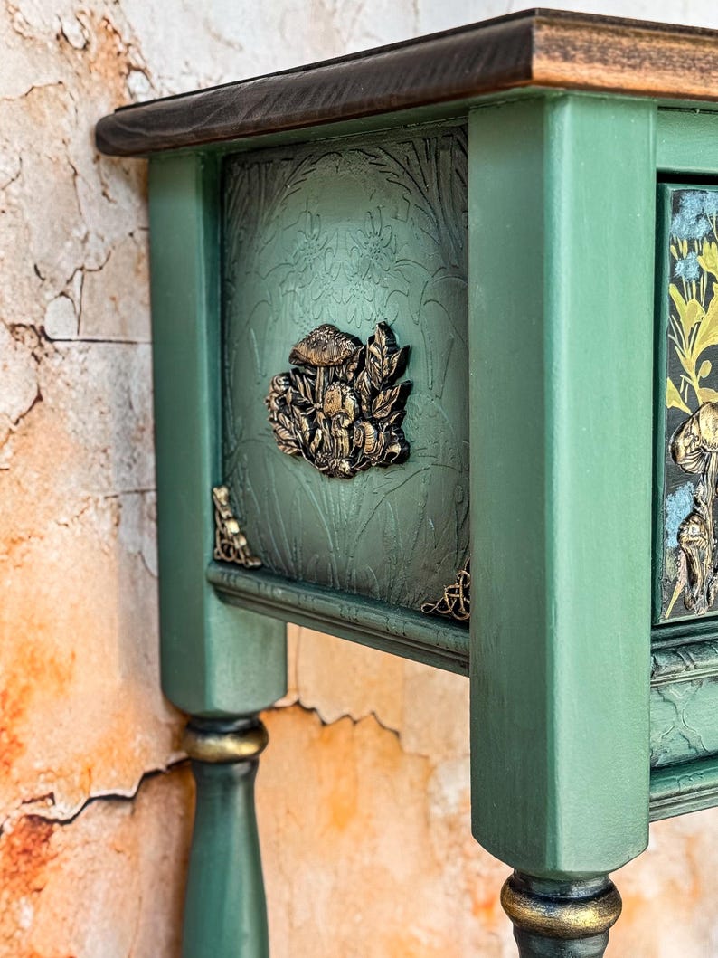 Unique green console table side view featuring raised sculpted mushrooms in golden tones on a dramatic deep green background, handcrafted accent furniture, luxury woodland inspired design.