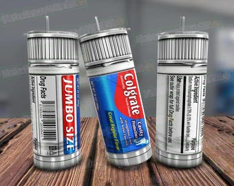 May include: Three silver tumblers with a design that looks like a toothpaste tube. The center tumbler has the text "Colgate Cavity Protection" and "Great Regular Flavor". The left tumbler has the text "Jumbo Size" and "Drug Facts". The right tumbler has the text "Drug Facts" and "Active Ingredient".
