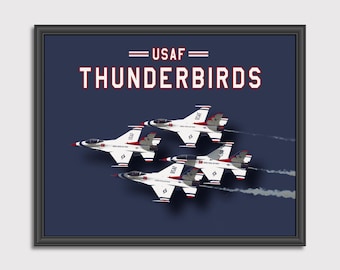 May include: A framed print featuring the USAF Thunderbirds air demonstration team. The print shows four F-16 fighter jets flying in formation against a dark blue background. The text "USAF Thunderbirds" is printed in white letters with red outlines.