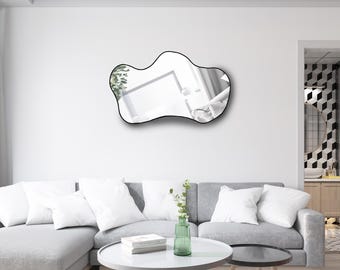 Pode incluir: Um espelho de parede com formato irregular de nuvem e uma moldura fina preta. A superfície refletora apresenta uma visão clara do espaço interior circundante, incluindo parte do teto branco e paredes de cores claras no reflexo.