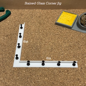 Può includere: Jig d'angolo in vetro colorato bianco con puntine nere. Il jig misura 15,24 cm per 15,24 cm.