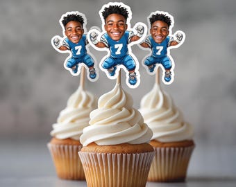 May include: Three cupcakes with white frosting topped with edible images of a cartoon football player wearing a blue jersey with the number 7.
