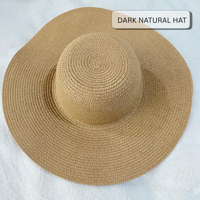 May include: A dark natural hat with a wide brim. The hat is made of woven material in a natural tan color. The crown is rounded and the brim is wide, providing ample shade. The text "DARK NATURAL HAT" is displayed on the top right.