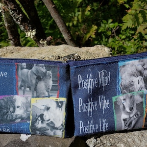 May include: Two blue zippered pouches with a collage of dog photos and inspirational text. The left pouch has the text "We don't have to agree to be kind to one another." and "Janis lan". The right pouch has the text "Positive Mind! Positive Vibe Positive Life."