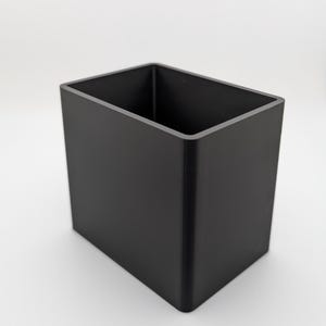 May include: A black rectangular storage container with a smooth surface.