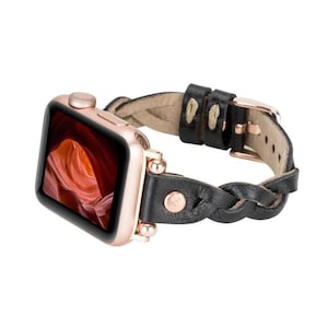 May include: A black braided leather watch band with rose gold hardware. The band is designed for an Apple Watch.
