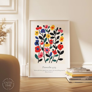 Può includere: Una stampa artistica incorniciata con un design floreale colorato. I fiori sono rossi, gialli, blu e rosa, con steli neri. Include il testo "Proverbi 4:23" e una citazione.