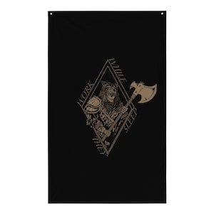 May include: A black rectangular wall banner featuring a tan-colored graphic of a skeletal warrior wearing a fur hood and armor, holding a battle axe. The design is enclosed in a diamond shape with the text WORK WHILE THEY SLEEP printed around it.