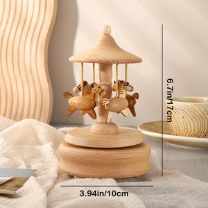May include: Wooden music box with a carousel design featuring four horses. The carousel is 6.7 inches tall and 3.94 inches in diameter.