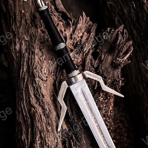 以下が含まれることがあります： 銀色の刃と黒い柄のファンタジーソード。剣には、柄と刃に複雑なデザインが施されており、刃に沿ってテキストが刻まれています。剣は、暗く質感のある背景に配置されています。