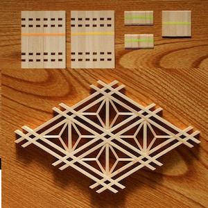 Op de afbeelding: Een geometrisch patroon van hout, gemaakt van dunne stroken hout, gerangschikt in de vorm van een ruit. Het patroon bestaat uit vier kleinere ruiten, elk met een stervormig middelpunt.