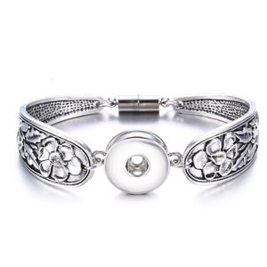 May include: Silver bracelet with a floral design and a snap-on charm. The bracelet has a magnetic clasp.