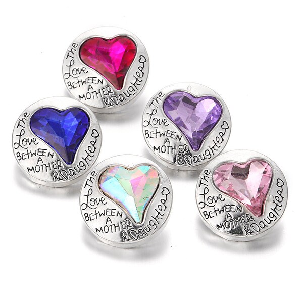 May include: Five heart-shaped buttons with a silver metal frame and a clear rhinestone heart in the center. Each button has the text "The Love Between A Mother & Daughter" inscribed around the edge. The rhinestones are in different colors: pink, purple, blue, iridescent, and red.