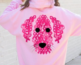 Puede incluir: Sudadera rosa con un gráfico de un perro hecho de cintas rosas. El perro tiene ojos negros y una nariz negra.