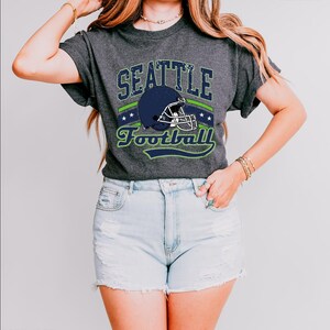a woman wearing a seattle football t - shirt
