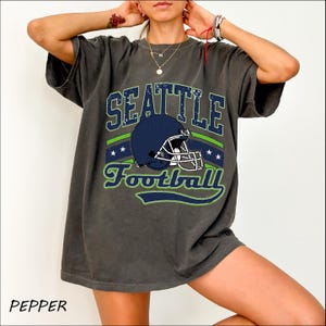 a woman wearing a seattle football t - shirt