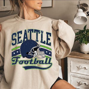 a woman wearing a sweatshirt that says seattle football