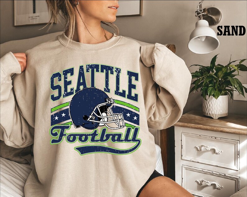 a woman wearing a sweatshirt that says seattle football