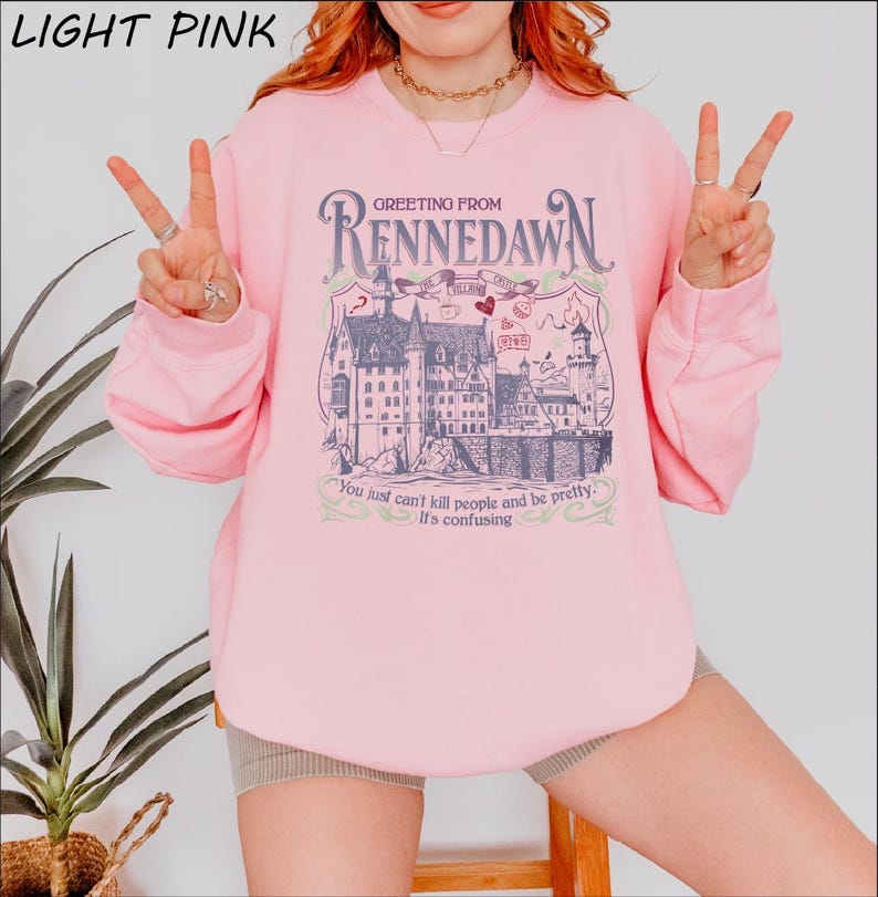 a woman wearing a pink shirt with a picture of a castle on it