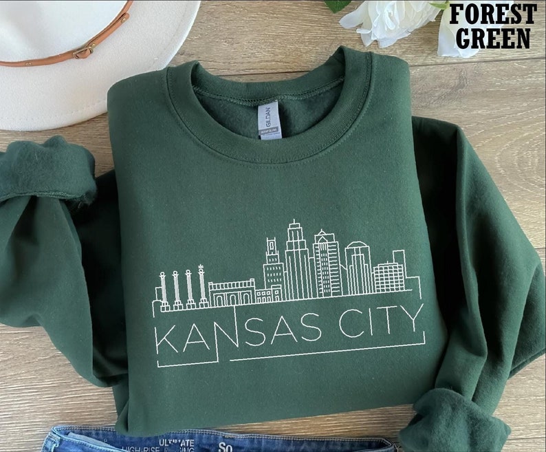May include: Forest green sweatshirt with a white outline of the Kansas City skyline and the text "KANSAS CITY".