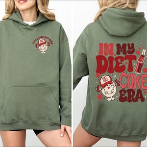a woman wearing a green hoodie that says in my diet coke era