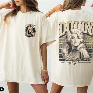 A woman wearing a white t-shirt with a graphic of Dolly Parton on the back.