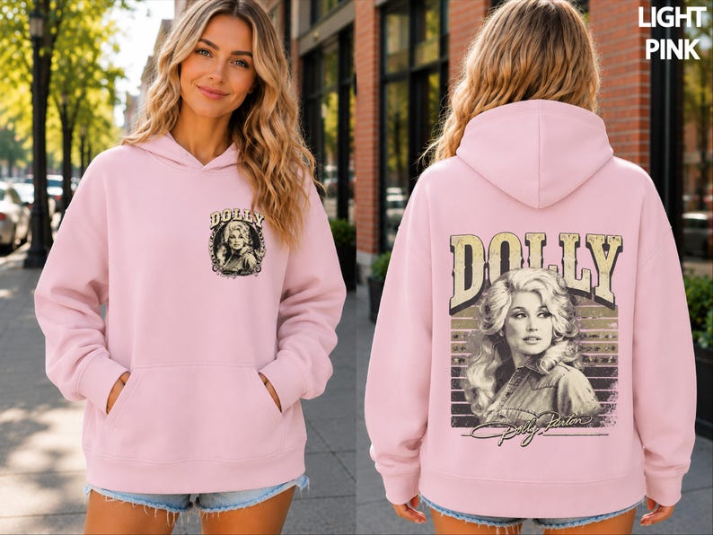 A woman wearing a pink hoodie with a graphic of a woman on the back.