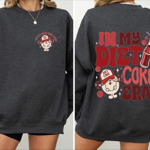 a woman wearing a sweatshirt that says in my diet coke era