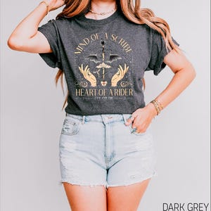 a woman wearing a black shirt and denim shorts