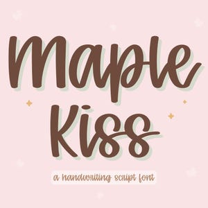 May include: A digital graphic featuring the words "Maple Kiss" in a brown, handwritten font with a shadow effect. The text "a handwriting script font" is below the main text, set against a light pink background with decorative elements.