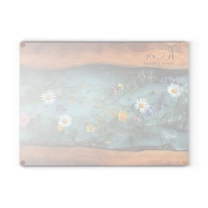 Puede incluir: Tabla de cortar rectangular con dise&ntilde;o floral. La tabla presenta un fondo azul claro con una variedad de flores y vegetaci&oacute;n coloridas. Los bordes son de color madera natural y el texto "med" es visible en la esquina superior derecha.