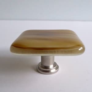 May include: Square glass cabinet knob with a brown and white swirl pattern and a silver metal base.