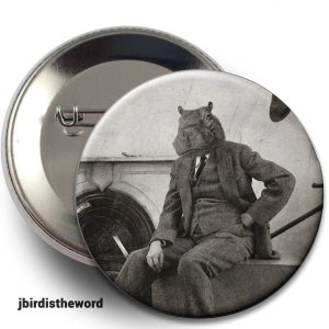 May include: A black and white photo of a person wearing a suit and a hippopotamus head. The person is sitting on a bench with their hand resting on their knee.