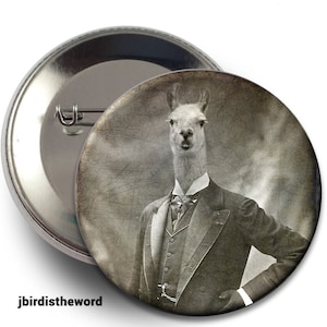 May include: A round button featuring a sepia-toned image of a llama dressed in a formal suit. The llama is the central focus, with the text "jbirdistheword" at the bottom. The button has a shiny metal backing and a pin.