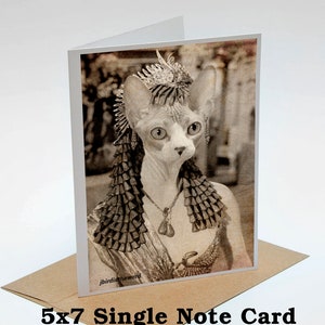 May include: A sepia-toned photo of a hairless cat wearing a crown and a necklace. The cat is looking to the right. The photo is printed on a 5x7 inch note card.
