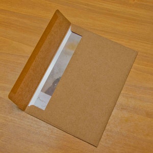 May include: A brown paper envelope with a white card inside. The card has handwritten text that says "Dear ...".