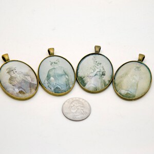 Op de afbeelding: Set van vijf ovale hangers met goudkleurige metalen frames. Elke hanger heeft een ander vintage-achtig beeld van een dier, waaronder een kat, een konijn en een hond.