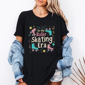 May include: Black t-shirt with a graphic design of roller skates and the text "In my roller skating era".