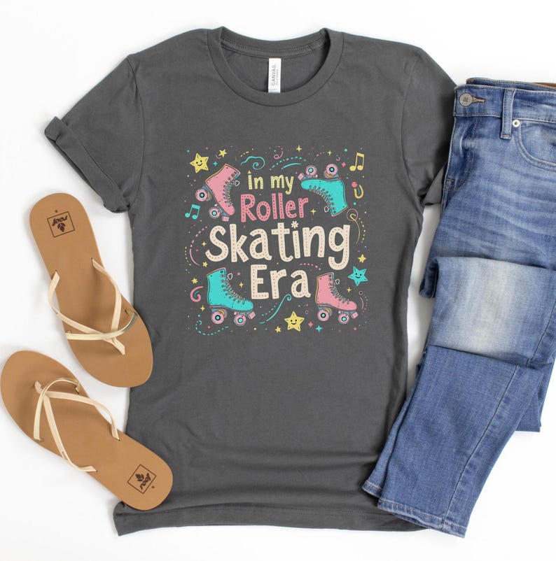 May include: A dark gray t-shirt with a colorful graphic design featuring roller skates and the text "In my Roller Skating Era".