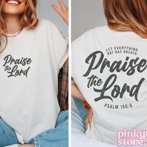 May include: White t-shirt with a black graphic that says "Praise the Lord" and "Psalm 150:6".